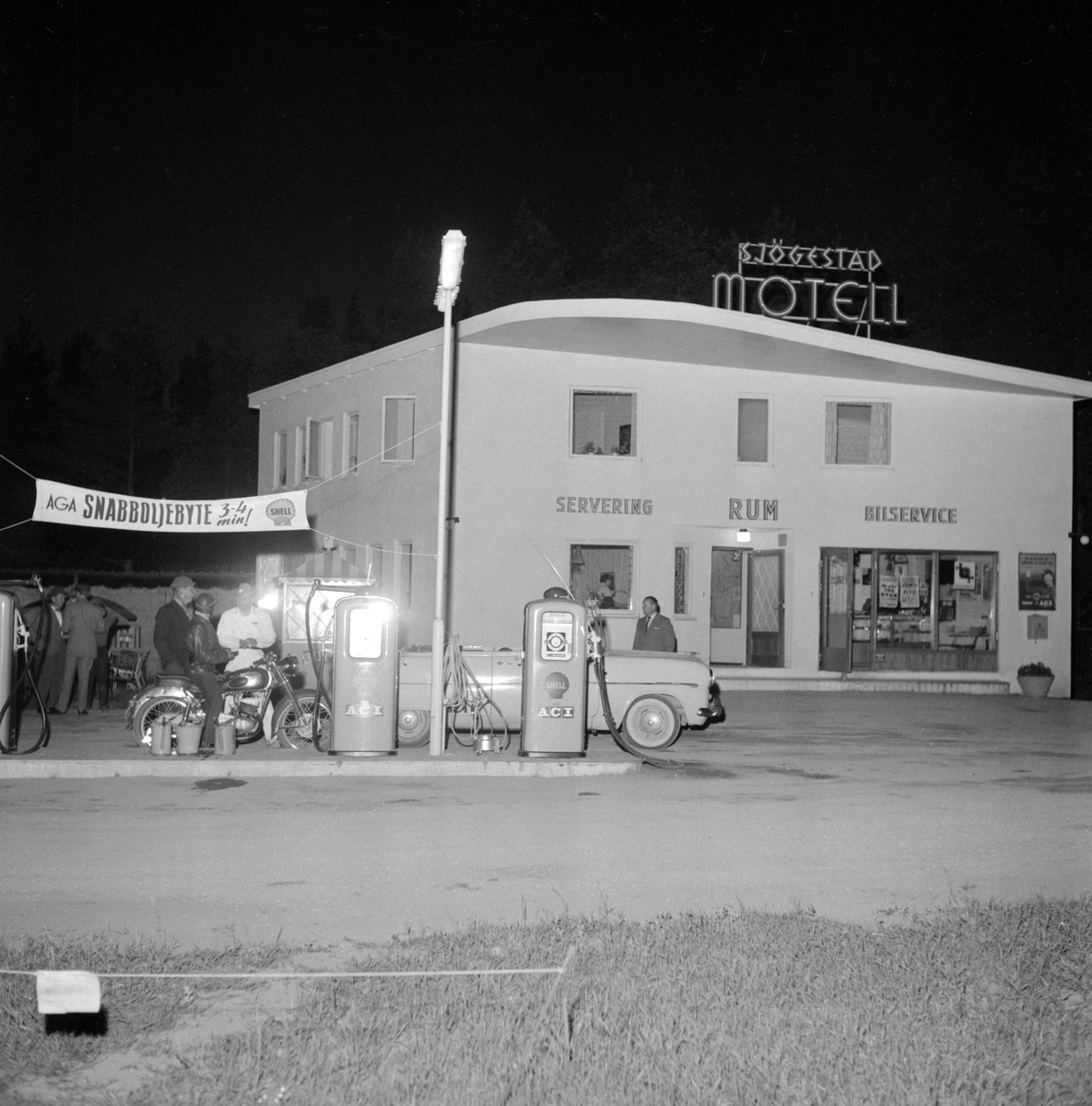 Sjögestad motell en sommarnatt 1956. Arrangemanget kring bilden är oklar men den visar i alla avseenden miljön före motellets utbyggnad under 1960-talet. Denna första del placerades invid dåvarande Riksväg 1 och stod klar 1954.
