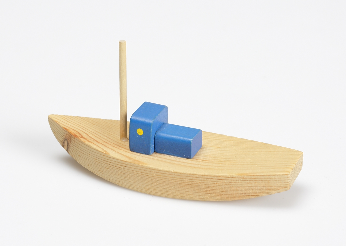 Leksaksbåt, tillverkad av furu. Trävit med blåmålad kajuta med gula ventiler. Försedd med liten mast.

Inskrivet i huvudkatalog 1982.