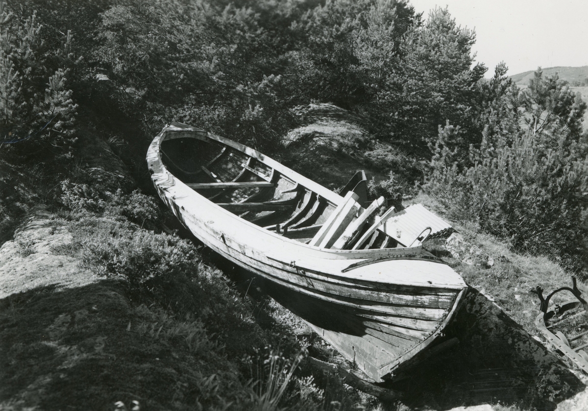 Motiv av en gammel båt som ligger på land. Ukjent.