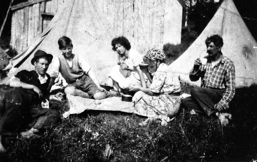 Familien Aleksandersen sitter foran teltet. Ca. 1945.
