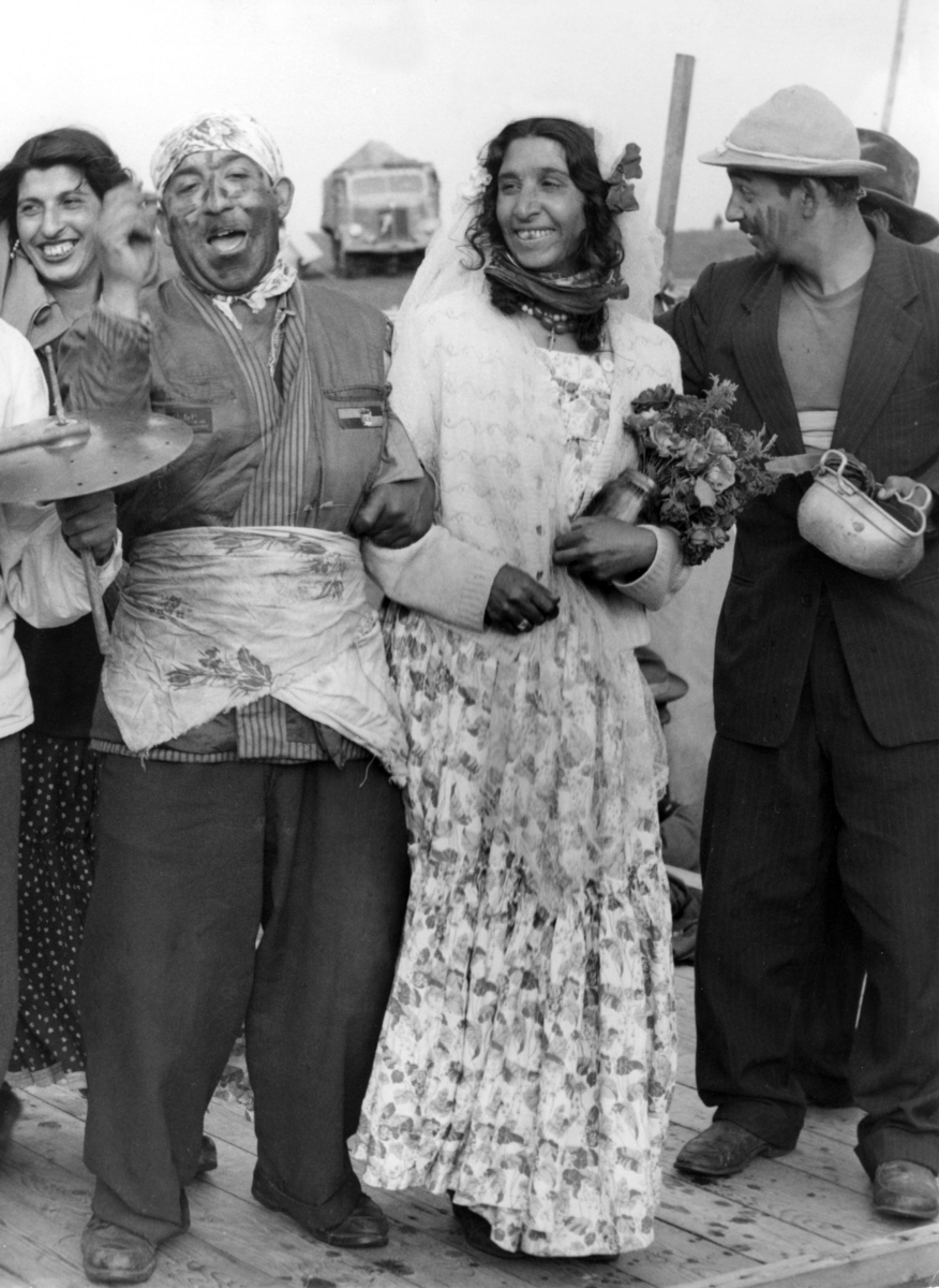 En grupp romer uppträder genom att spela upp ett bröllop på Kiviks marknad 1954. Marknader har ofta varit samlingsplatser för romer. Kivik och Sjöbos marknader var några av landets största och hit reste romer långväga för att spå, sälja sina hästar, hantverk eller uppträda med dans och musik.
