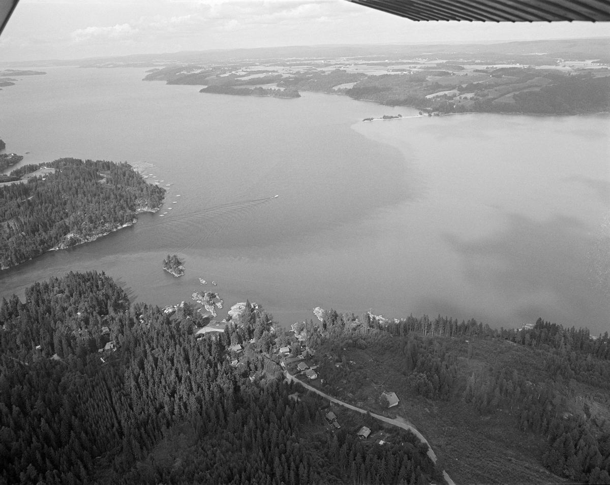 Flyfotografi fra innsjøen Øyerens utløp i Glomma ved Mørkfoss.  Bildet er tatt fra sør, med tettbebyggelsen Elvesletta i Trøgstad kommune i forgrunnen.  Ovenfor ser vi innløpet til Glomma og Mørkfoss til venstre, med den lille holmen Gåsa.  Fløtingssenteret Sleppetangen ligger mot stranda på østsida av høydedraget nord for elveinnløpet.  Der ble de fleste av tømmerslepene MB Mørkfos hentet fra Fetsund lenser i nordenden av Øyeren lagt.  Her ble vaierne som holdt slepene sammen på langs og på tvers, og som regel også «grimene» rundt «mosene» (tømmerbuntene), løst slik at tømmeret kunne gå fritt med elvestrømmen mot tømmerrennene forbi de nedenforliggende kraftverkene.