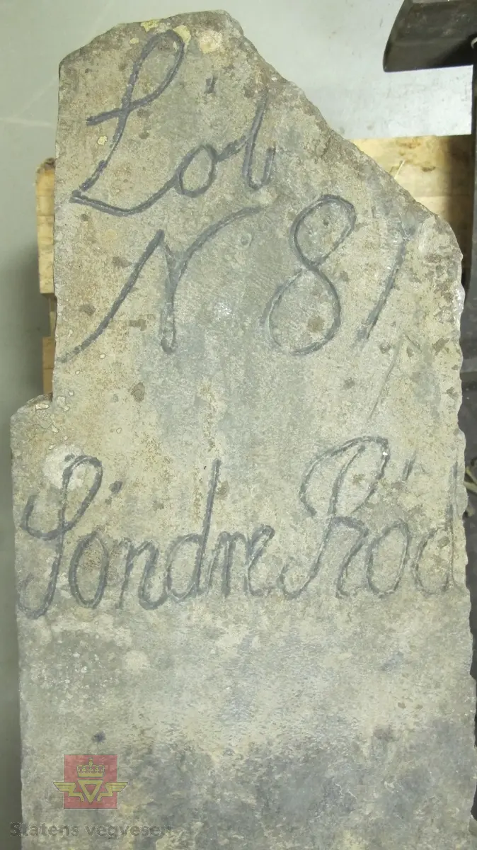 Grovt tilvirket stein med inskripsjon i øvre del. 
Steinen er merket: "Lòb N 81 Sòndre Ròd"