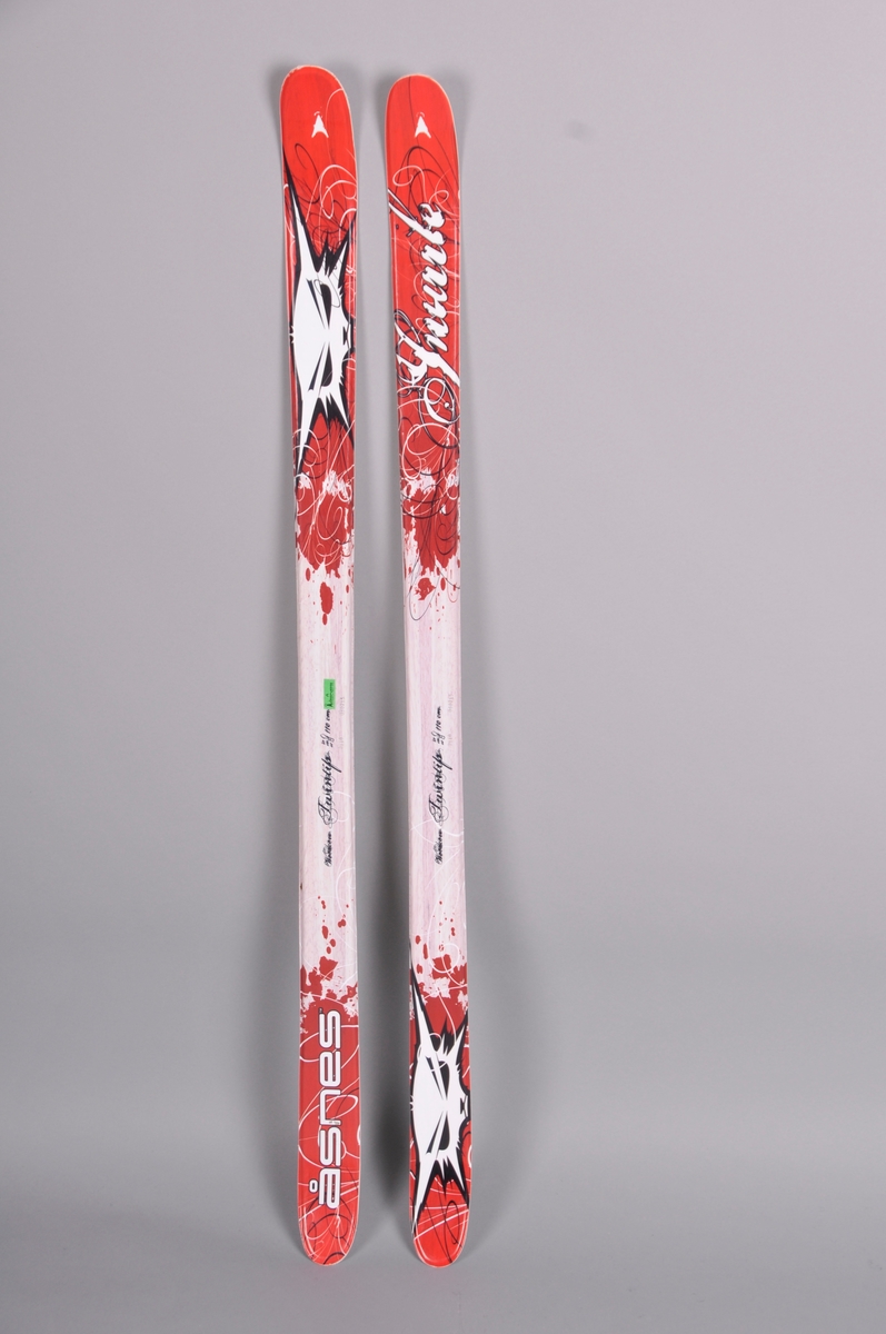 Barneski med tupp i begge endar, innsvinga mitt på. Fleire fargar og motiv oppe på skiet.