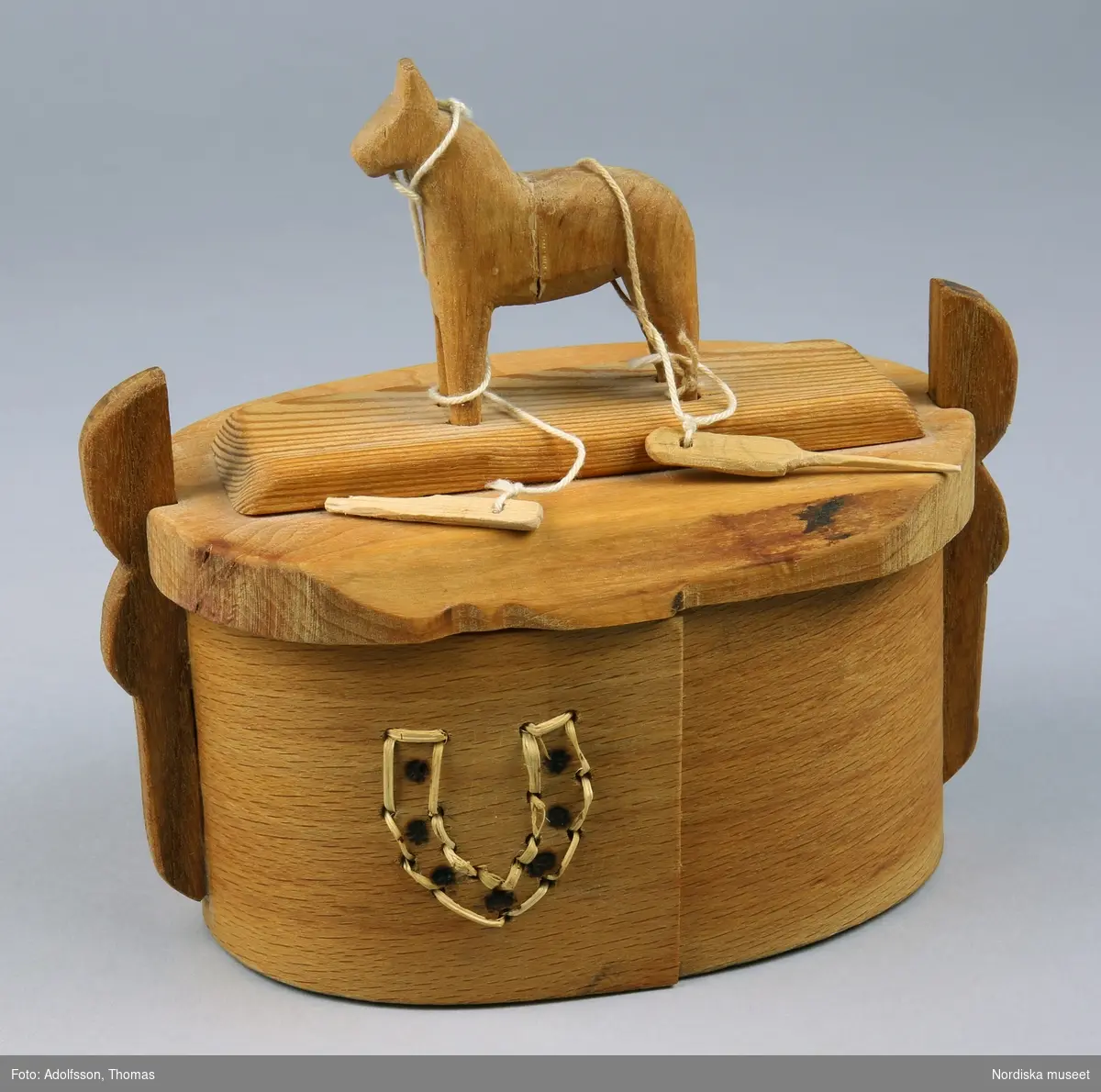 Svepask med dalahäst på locket, söm i form av hästsko på sidan av asken.