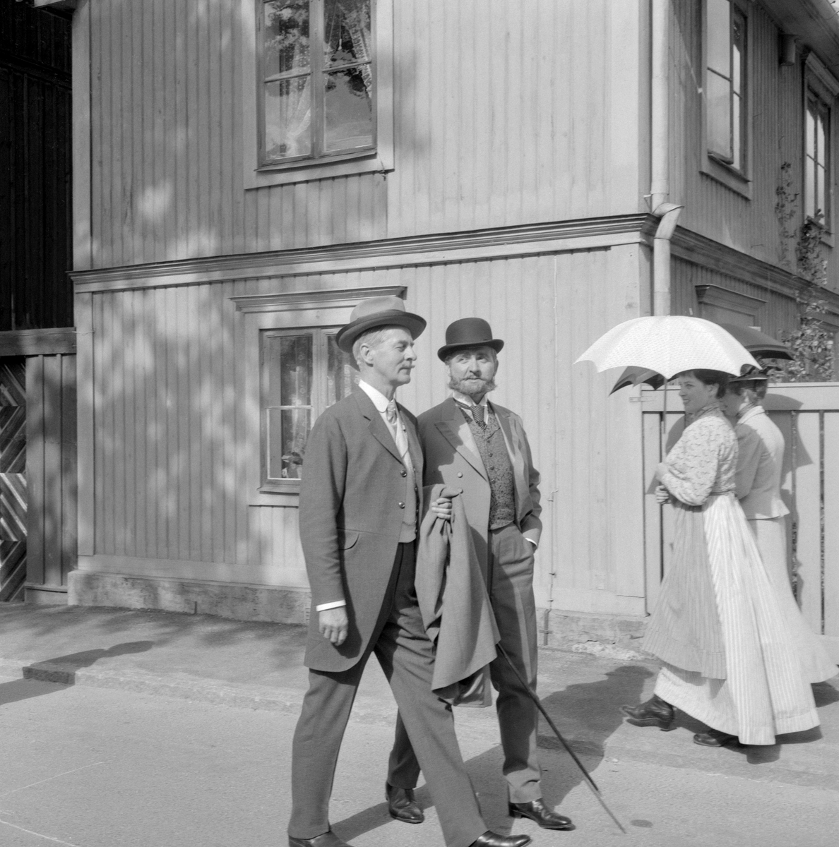 Scen från inspelningen av den romantiska komedin Lustgården i Vadstena 1961. På bilden vandrar Gunnar Björnstrand fram i rollen som adjunkt David Samuel Franzén och Stig Järrel i sin roll som lektor Ludvig Lundberg.