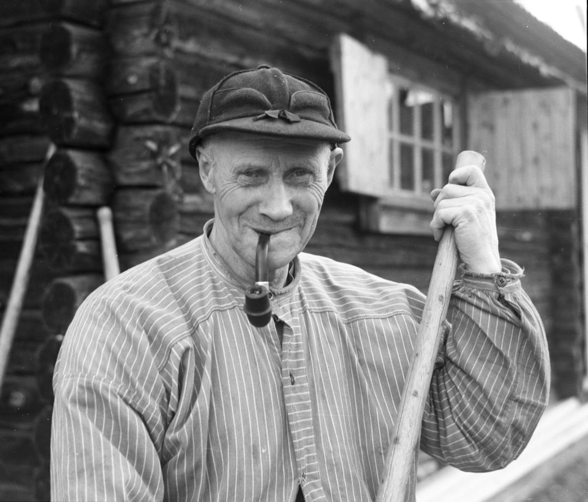 Ole Solberg, en kjent fløter fra Jømna, smiler med pipa i munnen og fløterhaka i henda