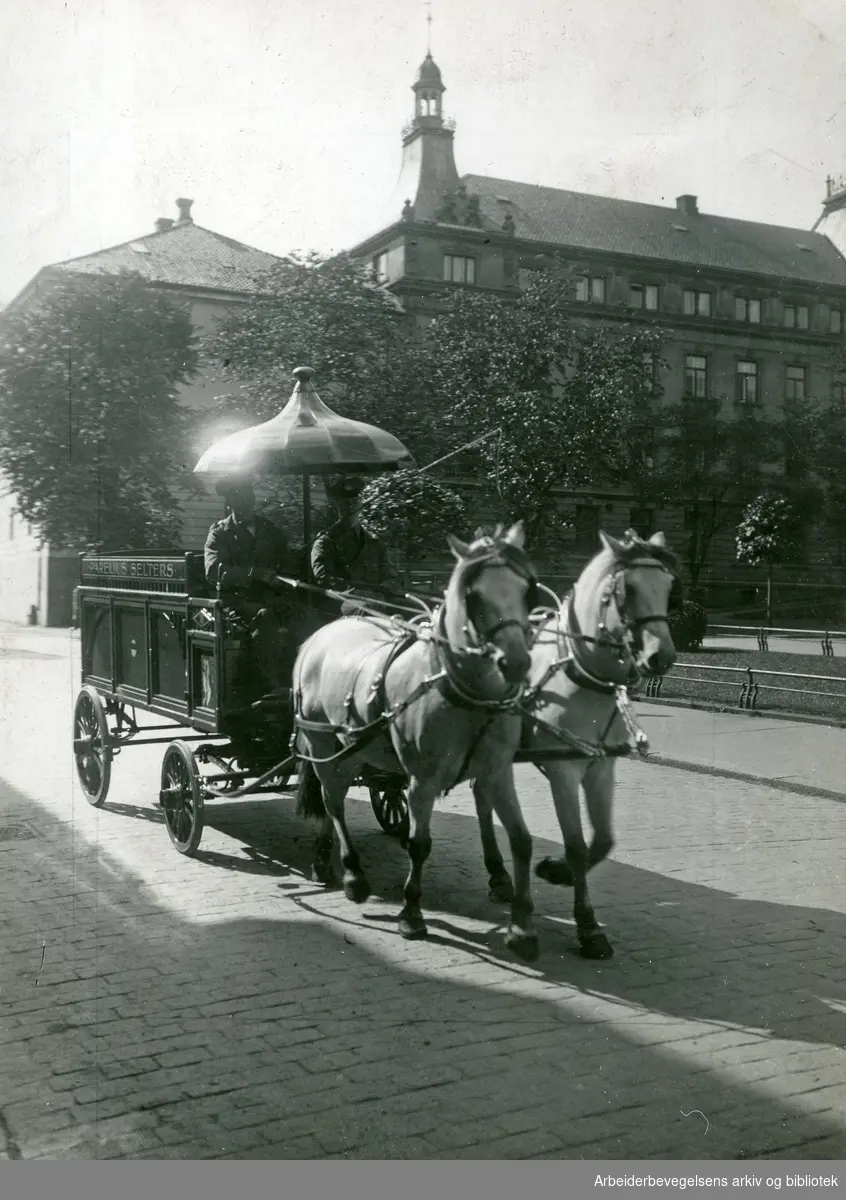 Hest og vogn med reklame for Parelius Selters. Parelius hadde anlagt sin fabrikk og bodde selv i flere år nesten vegg i vegg med Grand Hotel. Parelius ble kjøpt opp av mineralvannsfabrikken Nora i 1932..