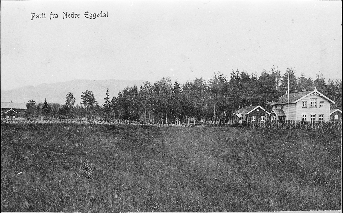Postkort med tittel: «Parti fra Nedre Eggedal». Enger skole, butikken, i bakgrunnen ungdomslokalet Leikvang. Ca. 1910. Se også SEM.F.00165 med lignende motiv.
