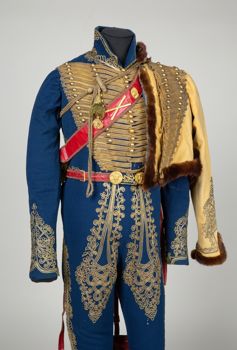 Blå jakke til uniform med dekor av lissebrodri og runde sølvknapper.