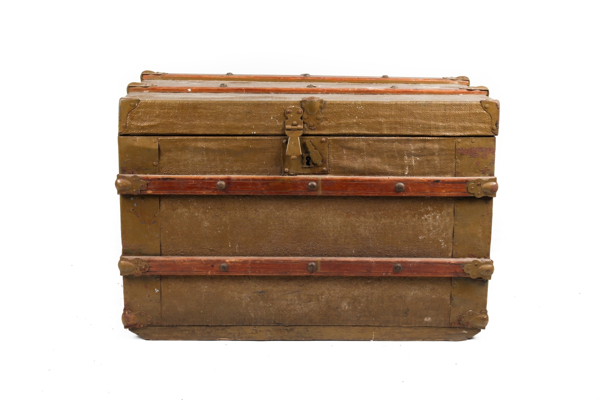 Koffert med flatt lokk, kledd med malt lerret. Utvendige beslag og trelister. Innvendig kledd med papirtapet.