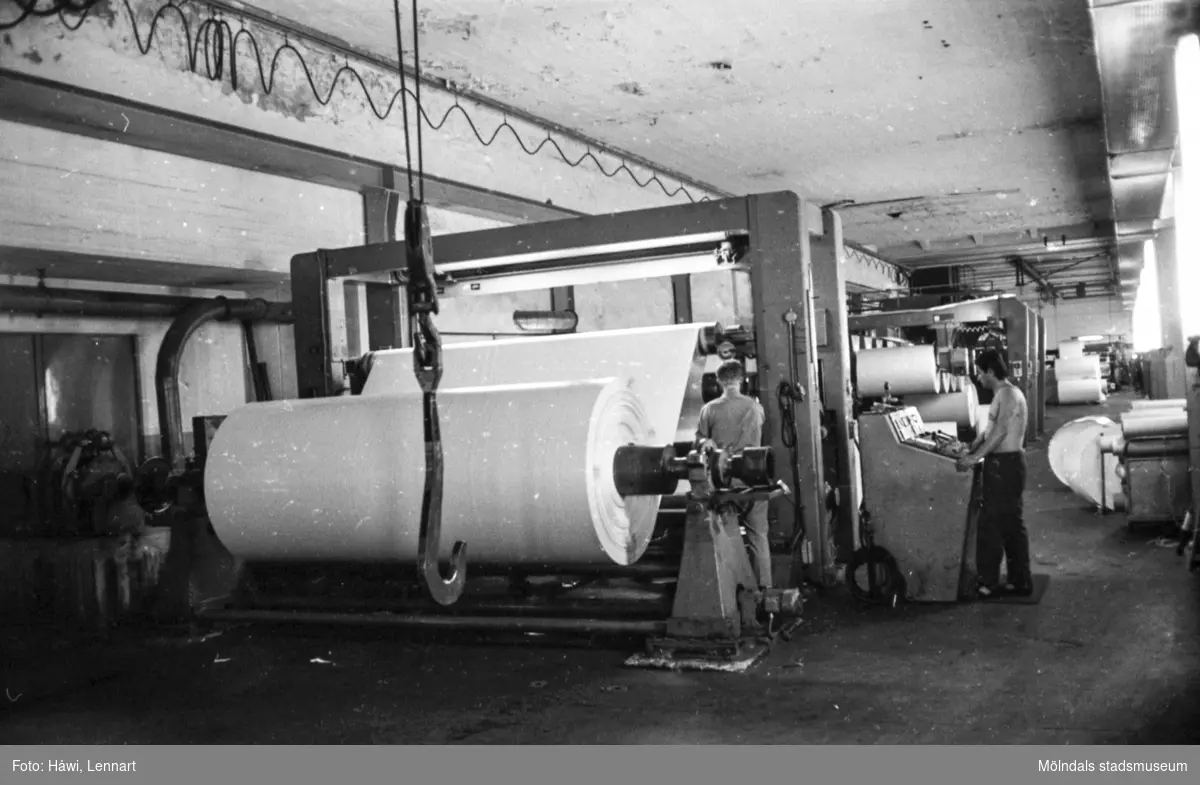 Män i arbete vid maskin. Rullmaskin 5, byggnad 10. Pappersbruket Papyrus, hösten 1970.