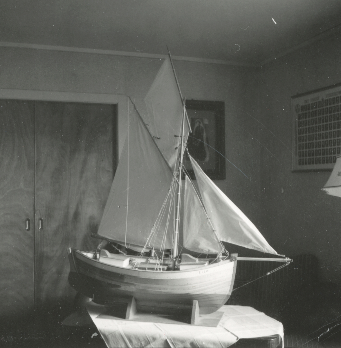 Gjenstandsfotografi av en båtmodell som står i ei stue. Båten heter Ella og er en modell av ei bankskøyte.
