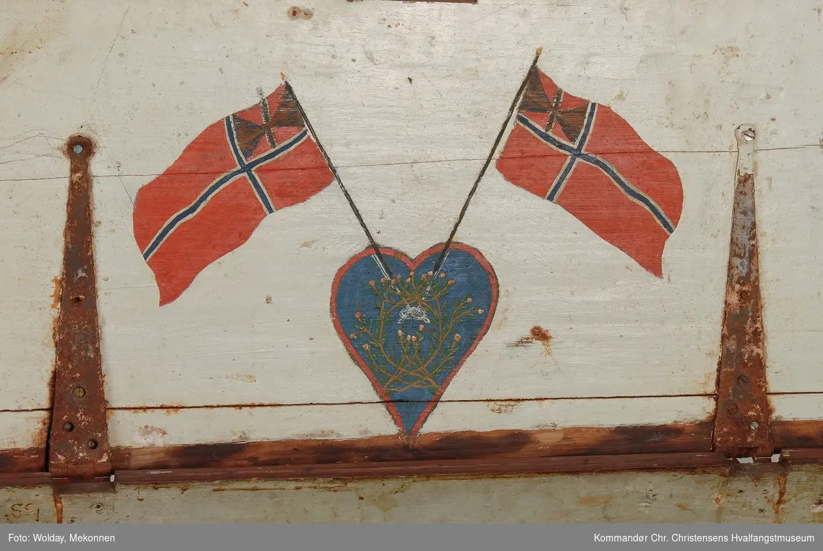 Krysset svensk og norsk unionsflagg, samt navn mellom med malte signalflagg-alfabet.