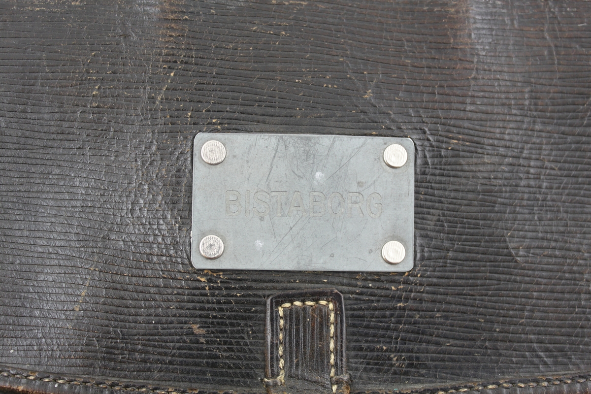 Postväska i läder med fyra öglor i överkant för låsning med låsten (varav en ögla saknas) samt en ögla straxt nedanför. Namnskylt på väskans klaff med inskription "Bistaborg".

Väskan är troligen använd såsom lösväska.