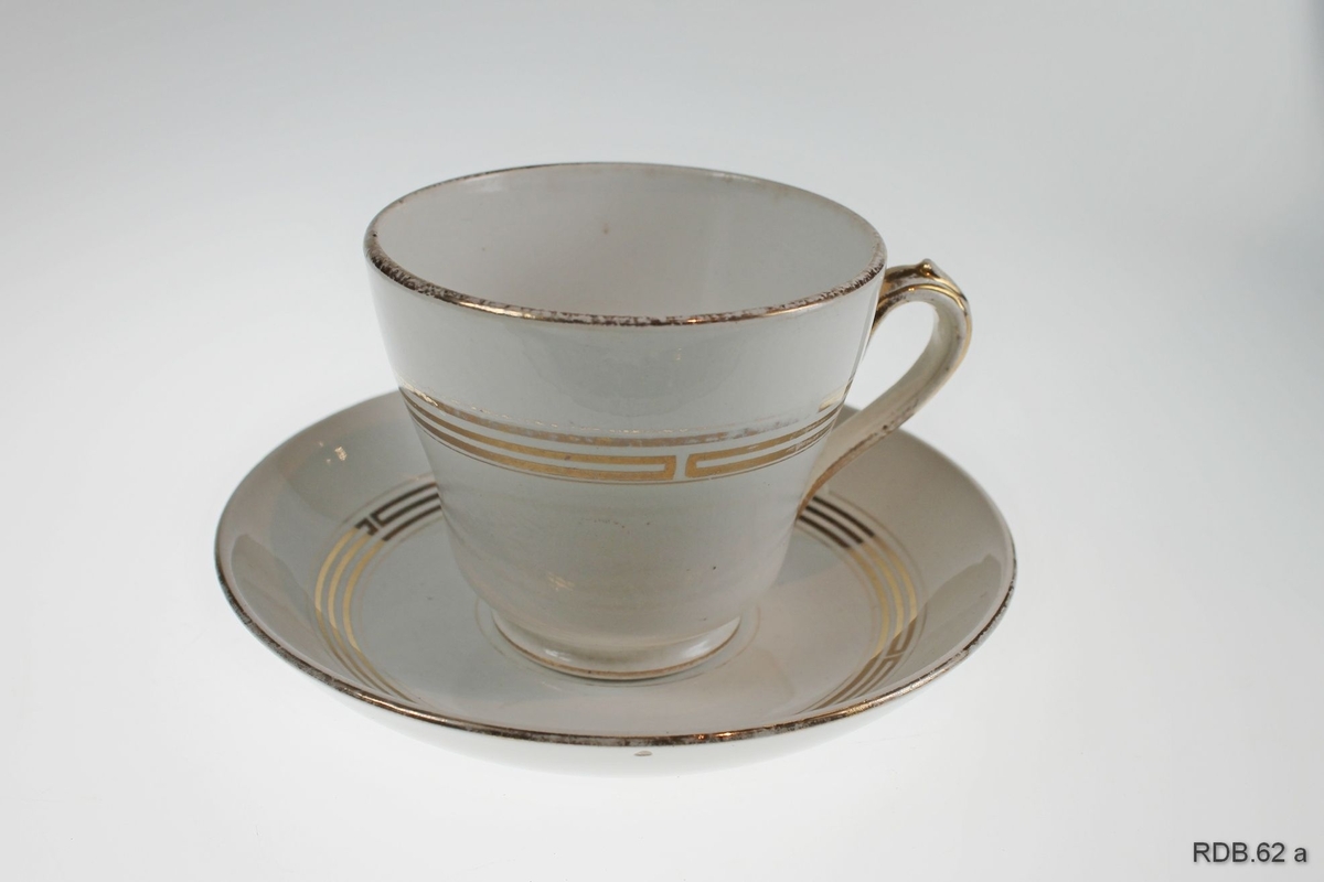 Hvit kaffekopp med skål. Både kopp og skål er dekorert med gullstriper, og det er gullkant både på kopp, skål og hank.