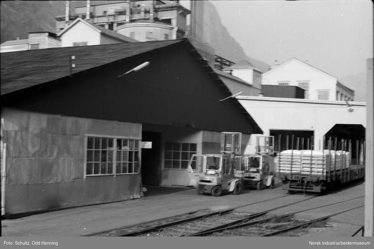 Gaffeltrucker og jernbanevogner med sekker utenfor Pakkeriet.