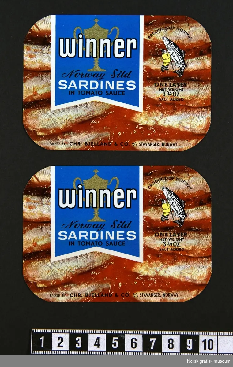 Etiketter med en fotografisk fremstilling av innholdet (sardiner i tomat). 
"Norway sild sardines in tomato sauce"