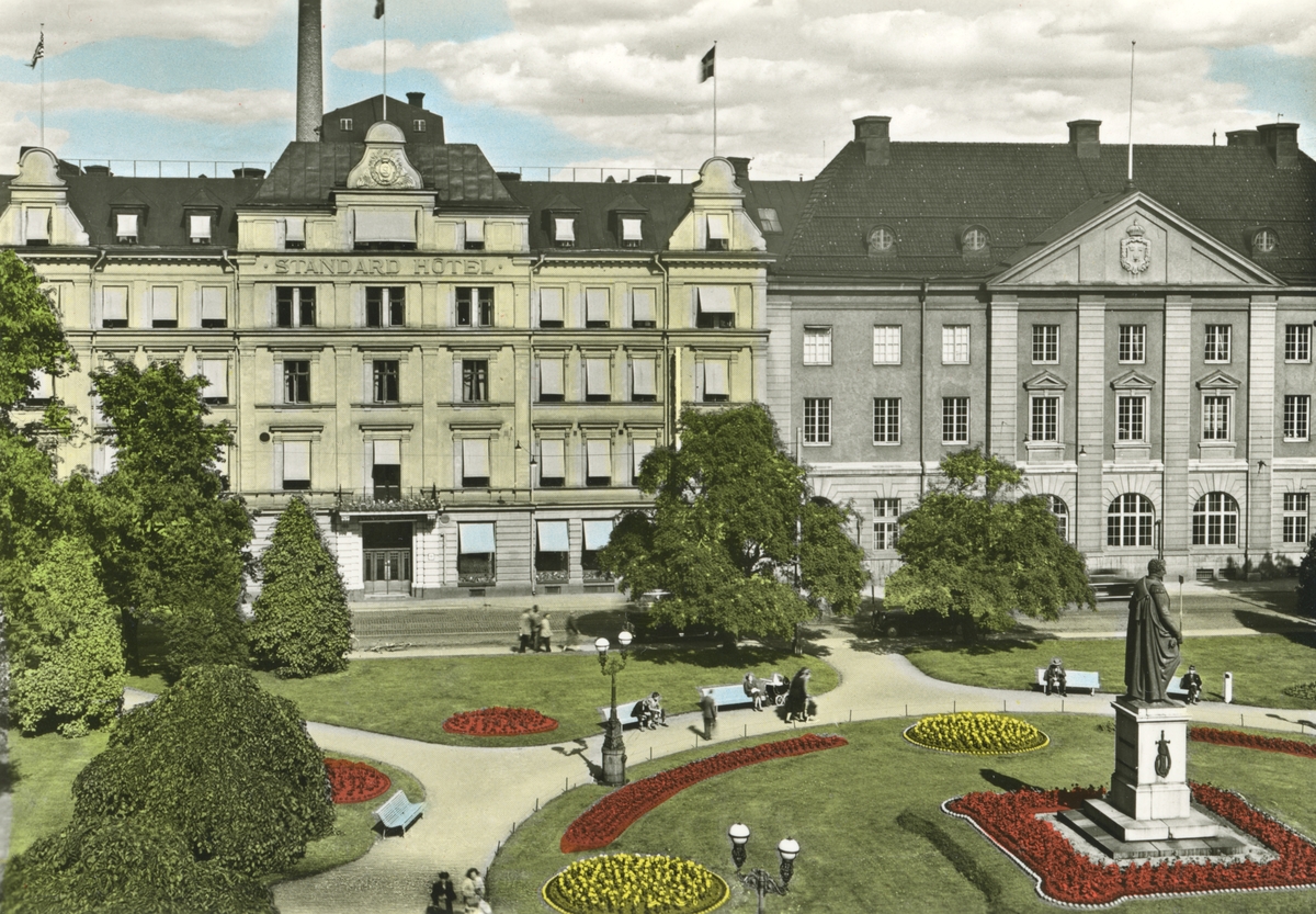 Vykort med vy över Carl-Johansparken mot Standard hotell och stadens postkontor i Norrköping. Tiden är omkring 1940.