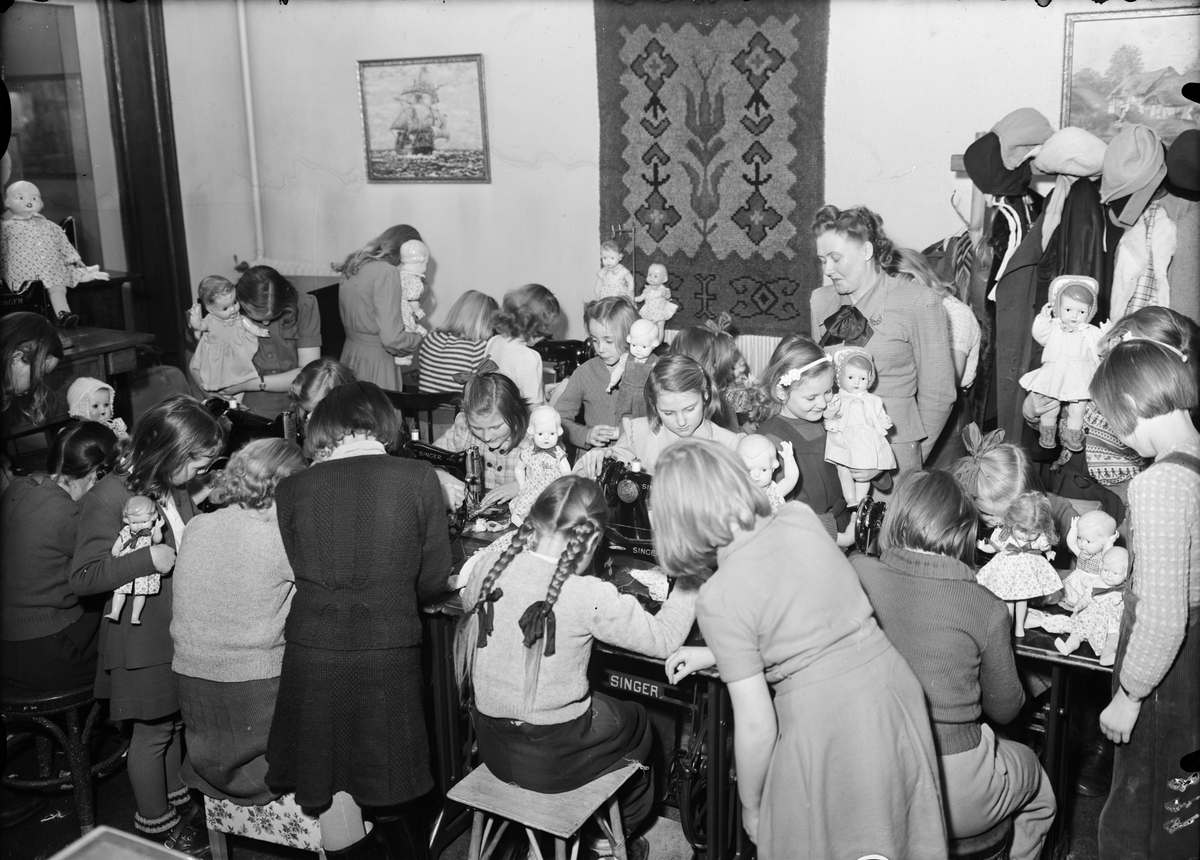 Barn med dockor syr på Singer symaskiner, Uppsala 1950