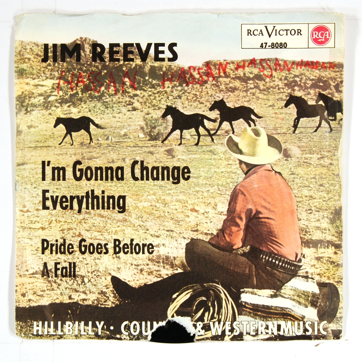 Bilde av Jim Reeves i cowboyklær. Reeves sitter med ryggen til kamera og ser på hester som løper forbi.