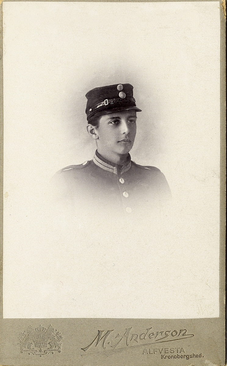 Porträttfoto av en ung man i militäruniform. 
Bröstbild, halvprofil. Ateljéfoto.