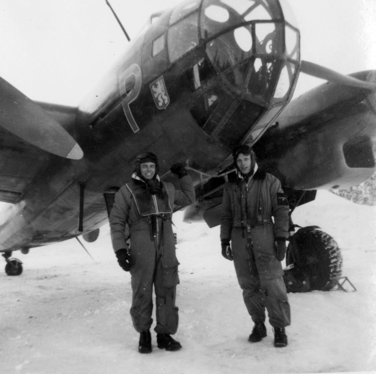 Flygmekaniker och flygförare från F 14 framför flygplan B 18 i februari 1946, i samband med planerad flygning Halmstad-Kiruna. Flygningen slutade i nödlandning i Härnösand den 10 februari.