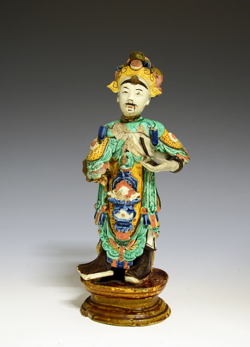 Prot: Chinesisk statuette. Fayance. En kineser med broget dragt og hovedsmykke.