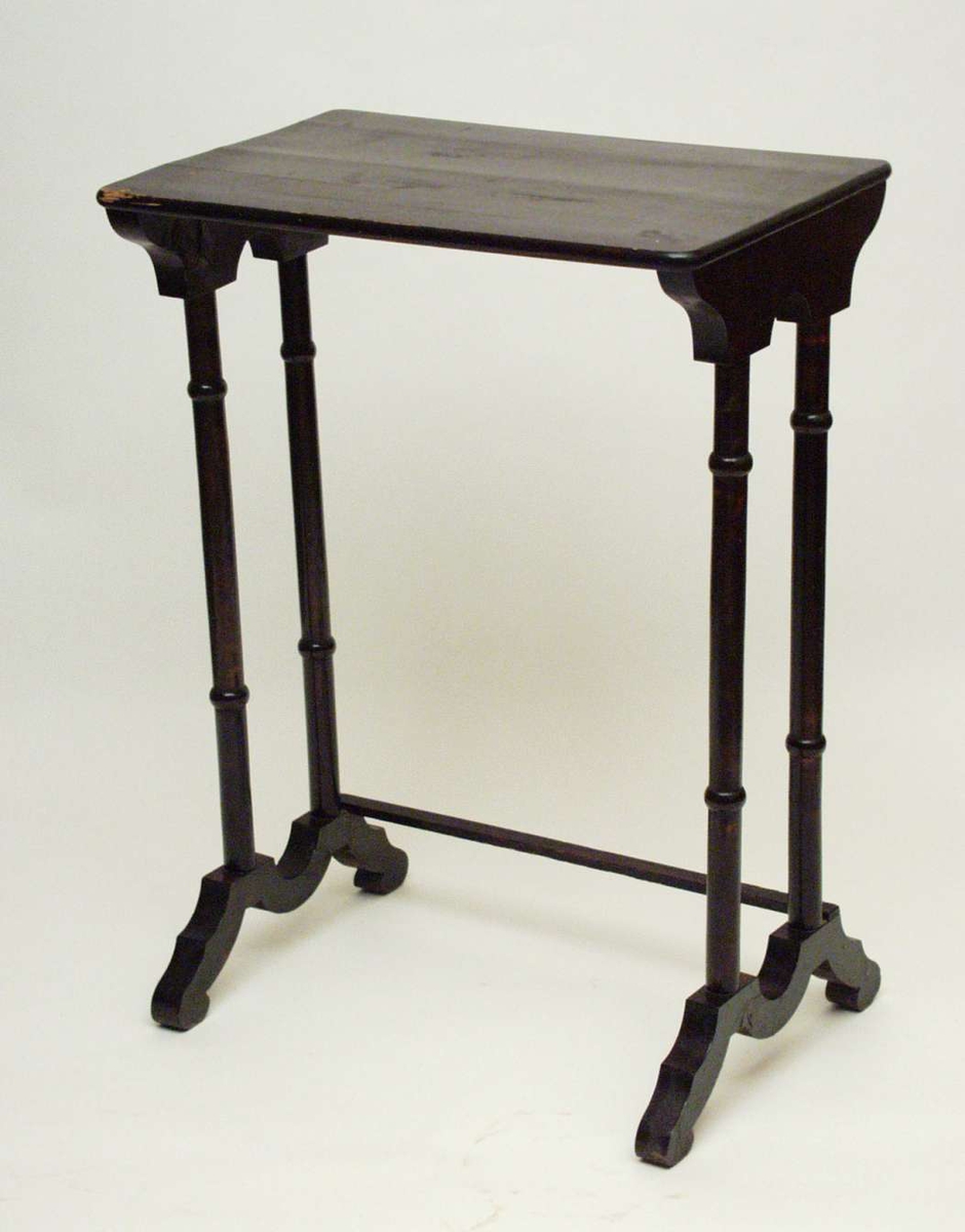 Settbord i bjørk beiset og lakkert mørk brunt. Fire søyler går på kortsidene ned i bølgebuende fotstykker. De er forbundet med en firkantet sprosse. Bordplaten er laget i gran.