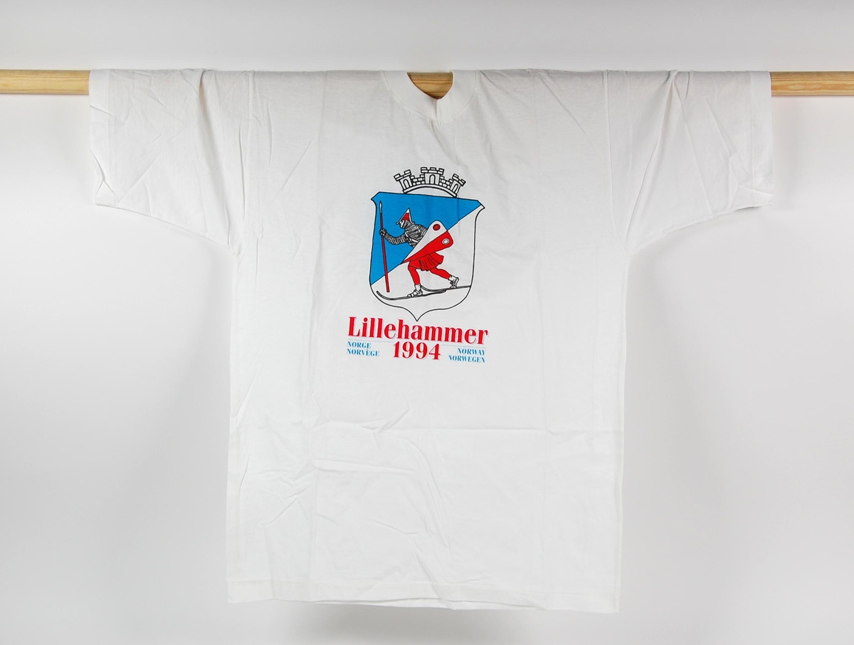 Hvit t-skjorte med flerfarget motiv. Motivet på t-skjorten er byvåpenet til Lillehammer.T-skjorten er i størrelse XXL (54) og er laget av bomull.