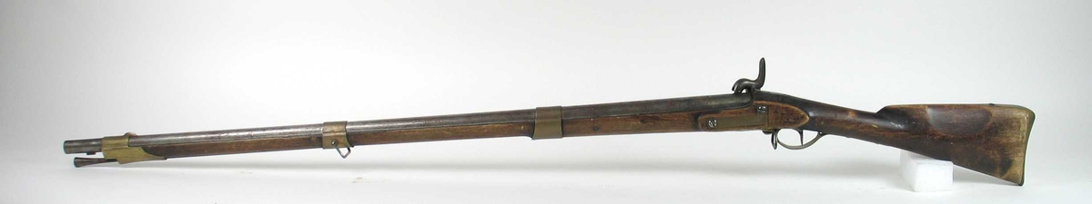 Svensk militært flintlåsgevær Modell 1815 ombygget til perkusjon. Nr 381
Klatt låsblikk avrundet foran og bak.
Rund glattløpet pipe .Baksikte i jern.Messing forsikte. Løpet er festet med tre messingbånd. 
Trekolbe med messing kolbekappe.
Ladestokk i jern
