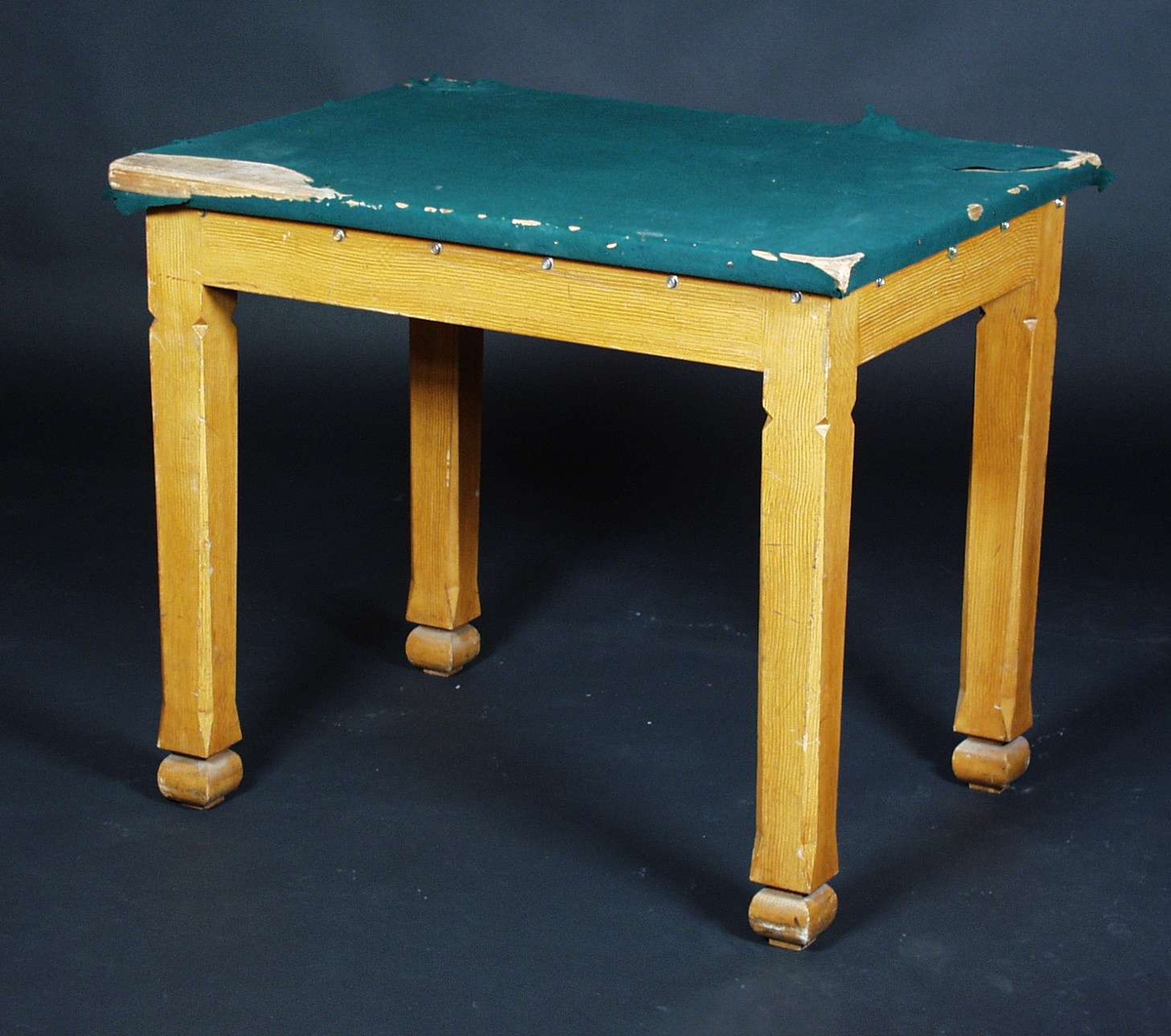 Et firkantetbord i furu med grønt filt på bordplaten.
