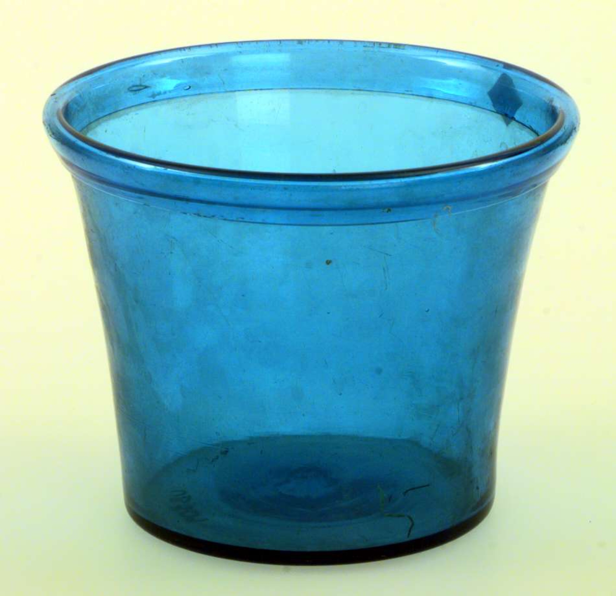 Urtepotte i blågrønt glass, ombrettet munningrand. Formen er konisk. 