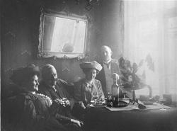 Fire mennesker samlet rundt et bord med noe "godt" i glassen