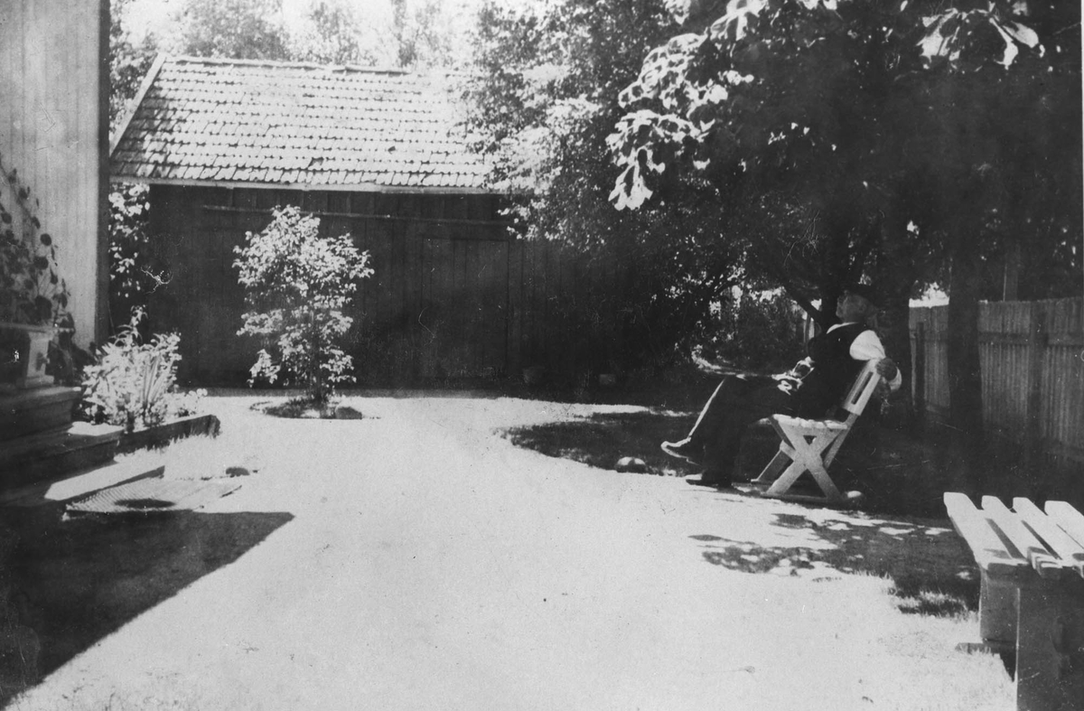 Herman Karlsen i bakgården på Sætre, uthuset i bakgrunden.