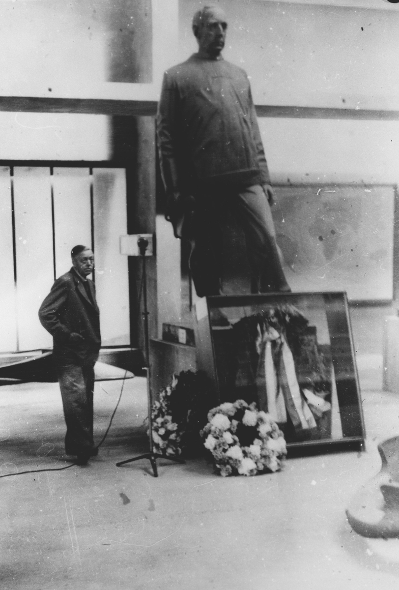 Jørgen Stubberud på Fram-museet ved en bekranset skulptur av Roald Amundsen