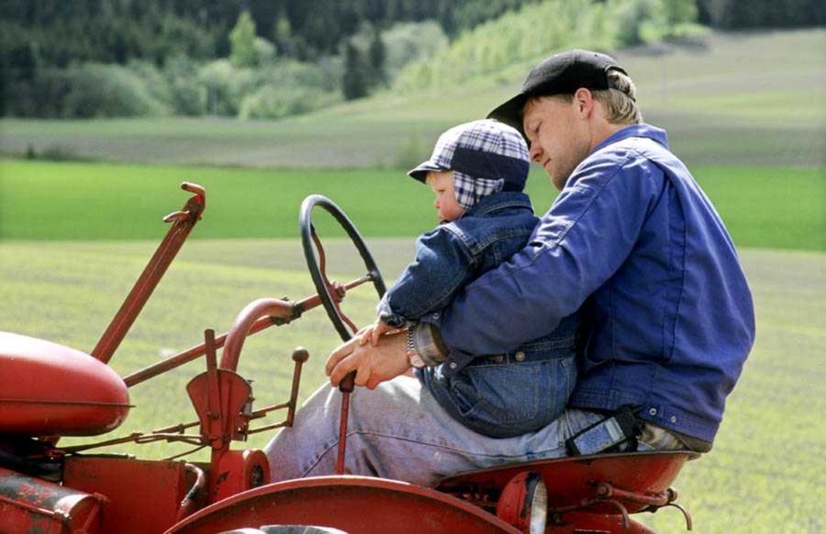 Dokumentasjon av drenering i forbindelse med åpning av ny utstilling: "Jordbrukets utvikling på Romerike" på Gamle Hvam. Mann og gutt sitter på traktor