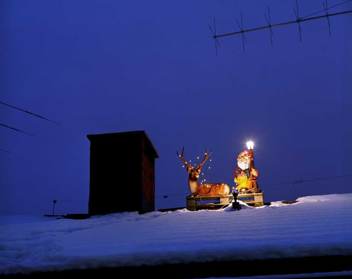 Julebelysning

Reinsdyr med lyslenke og nisse med lysende lykt på taket av enebolig