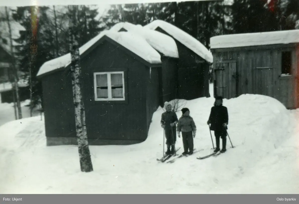 Barn på ski. Uthusene ved Rundmyrveien 1. Vinter.