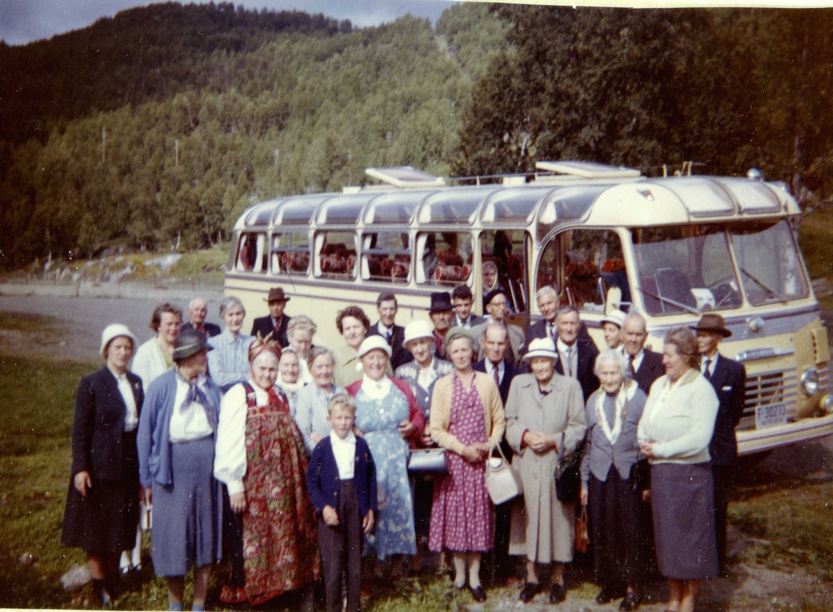 Rotneimingar på busstur. Sjåfør Guttorm Stuvebakken.
Bussen er registrert F-30273. Den tilhøyrde Gol Bilselskap og var av merket Commer,  truleg 1957-modell. Denne bussen gikk i rute Gol-Fagernes og Gol-Fagernes- Gjøvik-Lillehammer, i tillegg til å ha lokalruter i Gol.
Vart også brukt til turkjøring.