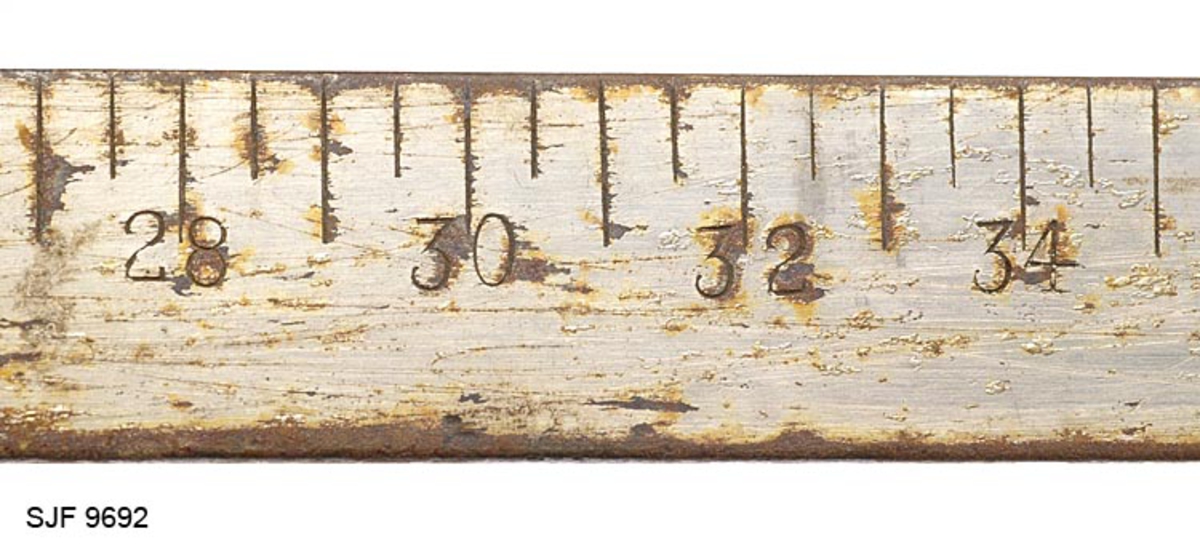 Toarmet cellulose-, battens- og prisklave patentert av Magnus Aanrud fra Fåberg i Oppland i 1933. 

Klaven består av en 46, 1 centimeter lang og 2, 8 centimeter bred linjal med en fast vinkelarm i den ene ytterenden og en skyvbar vinkelarm som posisjoneres der det passer ut fra diameteren på stokken som skal måles.  Linjalen er tappet gjennom og klinket sammen med den faste, ytre vinkelarmen.  Den skyvbare armen er forankret i en slags fal som omslutter linjalen.  På denne falen er det en knapp med riflet overflate, som antakelig har vært fjærbelastet (mot linjalens bakkant) slik at klavemålet kunne "låses".  Denne funksjonen er ikke intakt.  For å hindre at den skyvbare vinkelarmen faller av linjalen er det slått ei klinknagle med oppstående hoder på begge sider av den ytterenden av linjalen som ikke har noen fast vinkelarm.  Avstanden fra linjalens innerkant til ytterendene av vinkelarmene, som var så viktige ved målinga, er på 20 centimeter.  Den nevnte falen på den bevegelige vinkelarmen støter mot den faste vinkelarmen når avstanden mellom de to er på 9 centimeter, og den kan trekkes ut til en innbyrdes avstand på 40 centimeter før den butter mot de nevnte naglehodene.  Dette betyr at klaven har vært anvendelig for tømmer med diameter på mellom 9 og 40 centimeter.  Den ene bredsida av linjalen har en måleskala der hele og halve centimetre er markert med tverrstilte linjer.  Centimetermarkeringene er noe lengre enn halvcentimetrene.  Ved annenhver centimeter er det innhamret tall som angir lengemål.  Den andre bredsida av linjalen har også et linjesystem med tall.  Her er linjene radiært orientert i forhold til linjalens midtpunkt.  Også falen til den skyvbare vinkelarmen har en målskala.  Klaven er lagd av stål som er forniklet.  Ettersom akkurat dette eksemplaret nok hadde ligget i skogen ei stund før det ble funnet og gitt til Norsk Skogmuseum, er forniklinga stedvis avflasset.  Her framstår overflatene som rustbrune. 

Med en annen klave av samme type (SJF. 05345) fulgte "Bruksanvisning for Aanruds klave" med følgende ordlyd:

"Linjalen har en grafisk kubikktabell som angir kubikkinnholdet i dm3.  Denne er inndelt i strek for hver tier fra 30 dm3 til 500 dm3, i strek for hver 20 dm3 fra 500 dm3 til 700 dm3, i strek for hver 50 dm3 fra 700 dm3 til 1000 dm3.  30 dm3 er merket med 3, 40 dm3 med 4 osv. til 100 merket med et stort 1-tall, 200 med et stort 2-tall osv. 

Cellulosetømmer. 
Når midtdiameteren er målt, avleses stokkens kubikkinnhold på linjalen ved det tall på lengdeskalaen som tilsvarer stokkens lengde.  Ønsker man prisen, stilles lengdeskalaens 10er på stokkens kubikktall og prisen avleses på linjalen ved det punkt på lengdeskalaen som tilsvarer vedk. klasses kubikkmeterpris. 

Skurtømmer (Bjelk). 
Når stokkens toppdiameter er målt, merker man det tall på linjalen som ligger rett under stokkens lengdetall.  Deretter flyttes lengdeskalaens 0-punkt til detet tall.  Stokkens kubikkinnhold avleses deretter på samme måte som for slipen - altså på nederste lengdeskala."

Bruksanvisningen for denne klavetypen inneholder også ei tegning av kubikkskalaen samt en beskrivelse av redskapet.  Dokumentet finnes i brevmappe for innkomne gjenstander under SJF.05345.