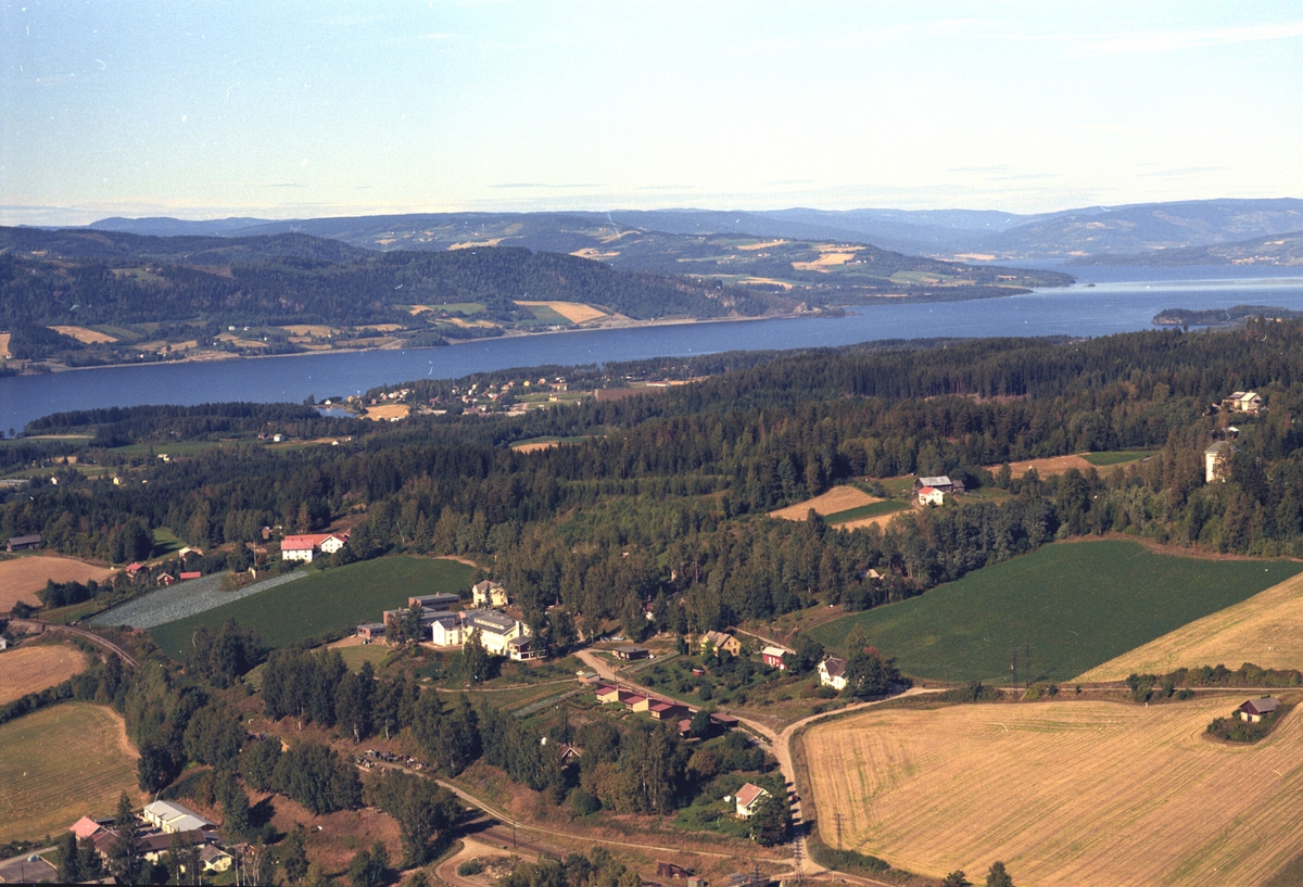 Flyfoto, bebyggelse ved Ringsaker Folkehøgskole, Mjøsa, Biri, Ring i bakgrunnen.