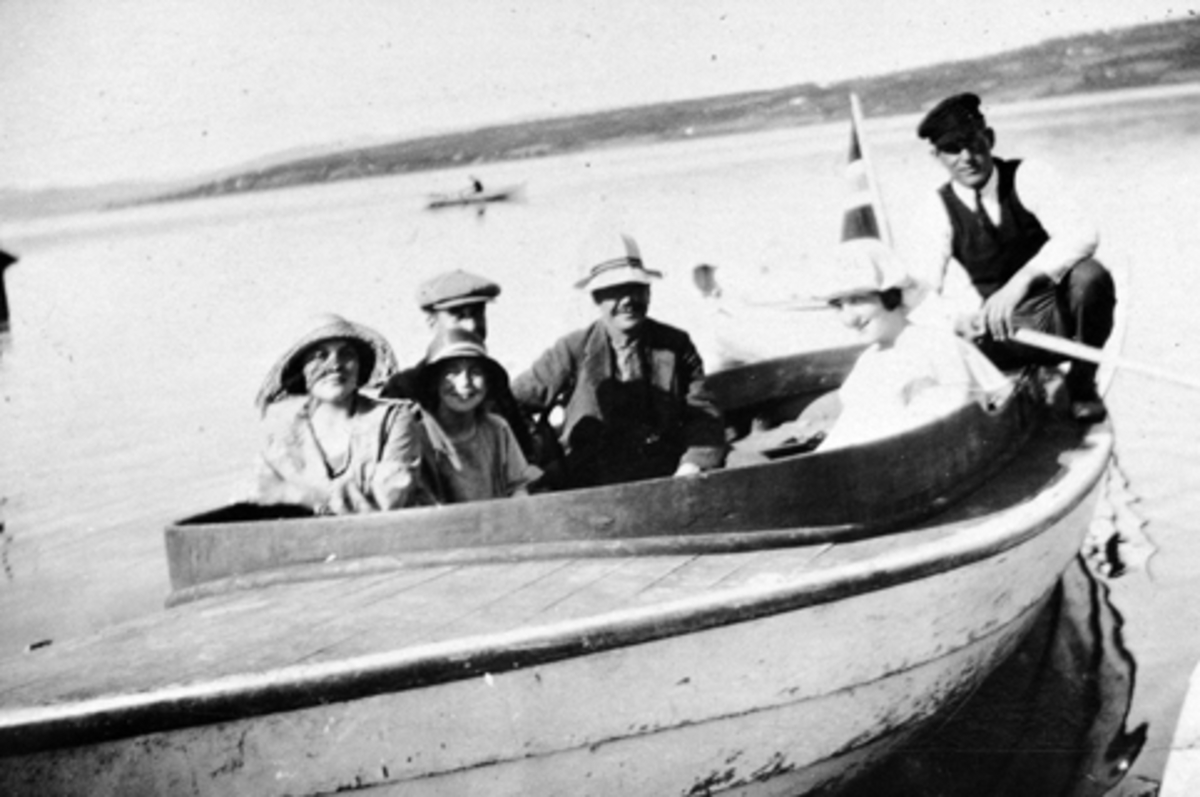 Motorbåt med 5 passasjerer og Nils Sørbo (1888-1970) fra Bakkom, Mengshoel som båtfører.