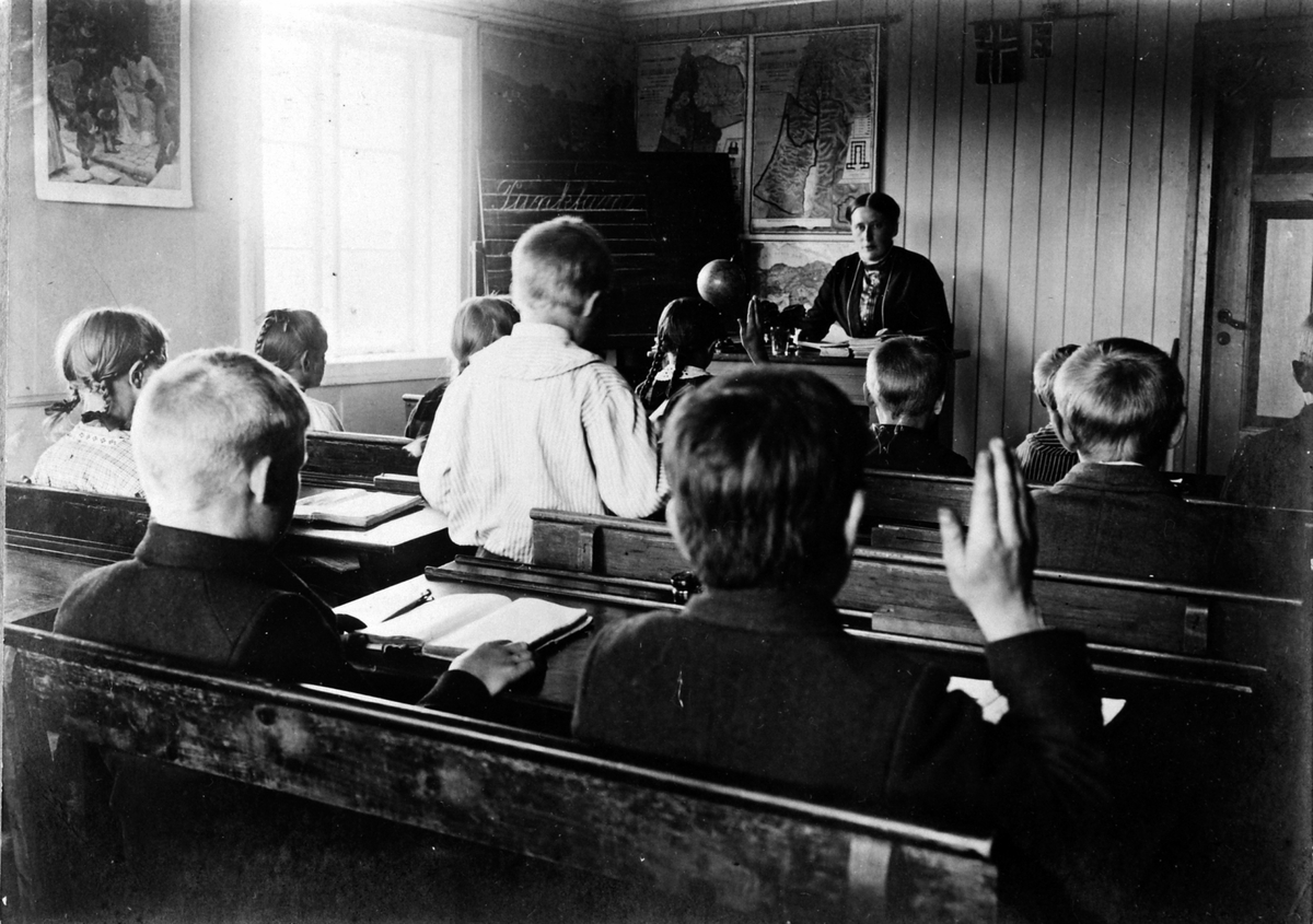 Undervisning på Solheim skole, Ringsaker i 1907, med lærer Magnhild Baardseth og elever ved dobbeltpulter.