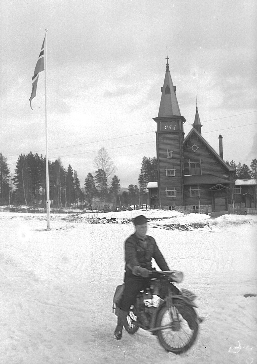 En mann på motorsykkel foran Nordre Osen kirke i Åmot