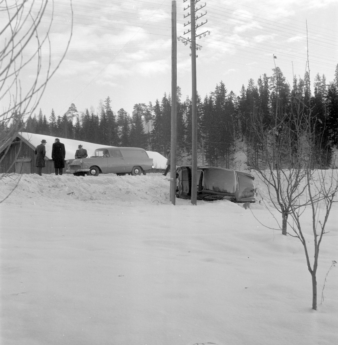 Bil kolisjon, bilvelt. Bil liggende på siden i grøfta. Vinter. Mennesker. 
Moelven foto 1960-åra. 