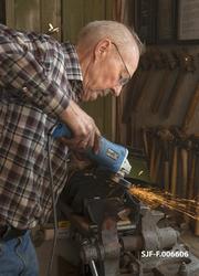 Smeden Oddbjørn Knudsen sliper eggen på ei merkeøks, der nak