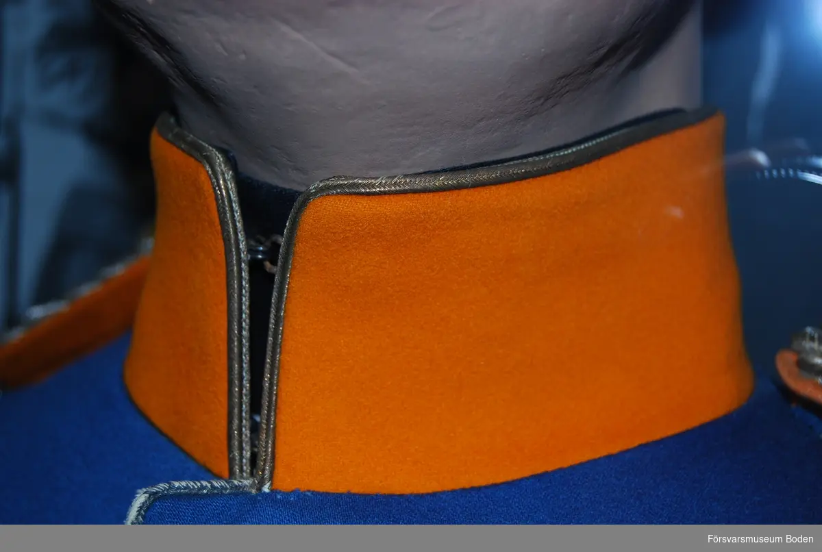 Mellanblå med regementets orangegula färg på kragen och på axelklaffarnas mattor. Enkel rad med knappar av regementets modell.