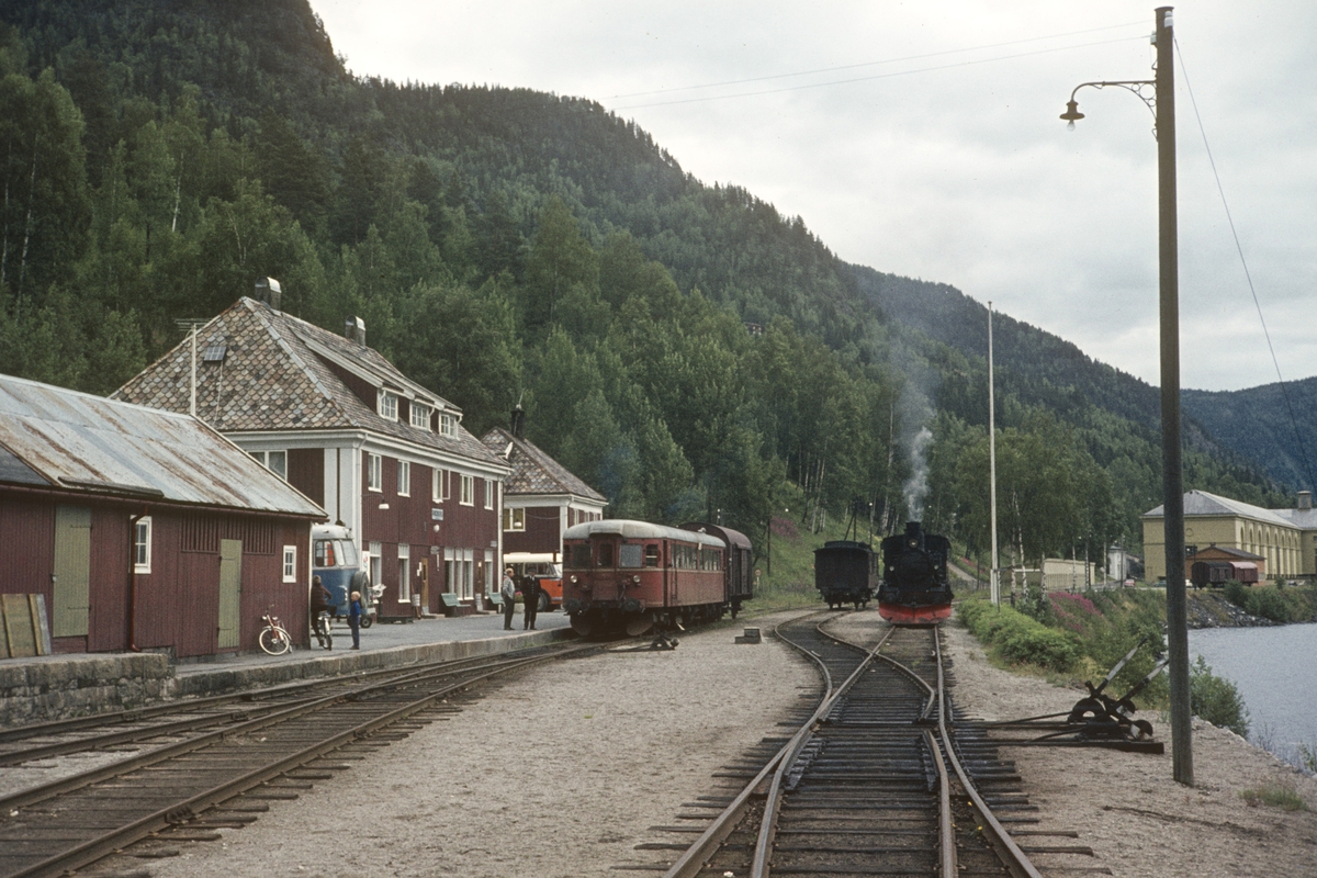Damplokomotiv 21b nr. 252 med godstog til Kongsberg i spor 2 på Rødberg stasjon. Til venstre dieselmotorvogn litra Bmdo 86 med persontog til Kongsberg til høyre.