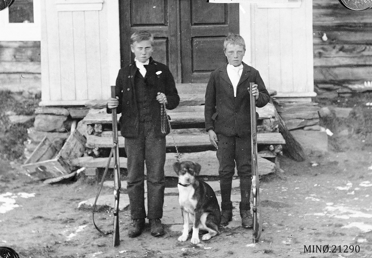 To unge gutter med gevær og hund